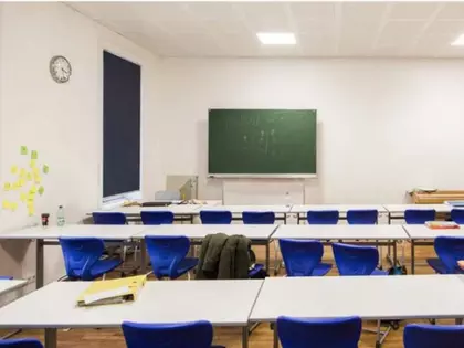 Sacré Coeur Klassenraum mit Tafel und Tischen und Sessel